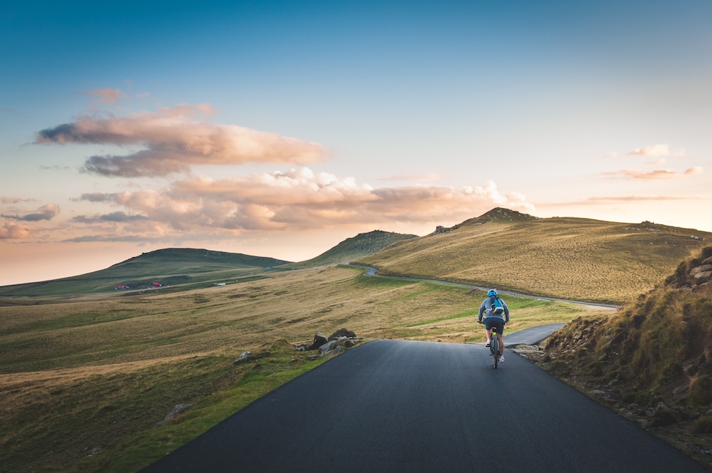 Road with a cyclist surrounded by mountains